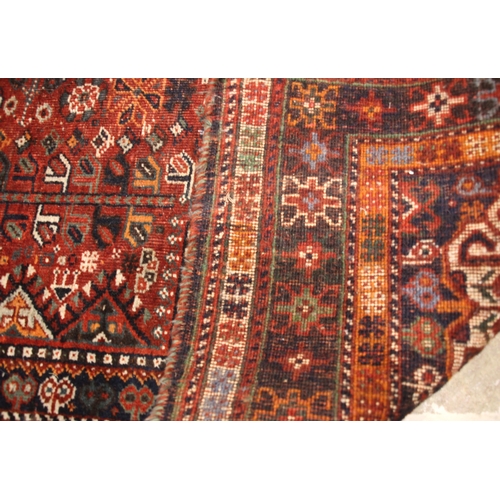 634 - A Persian Qashqai rug, in red, blue and ivory colourways, the central medallion upon a red field fil... 