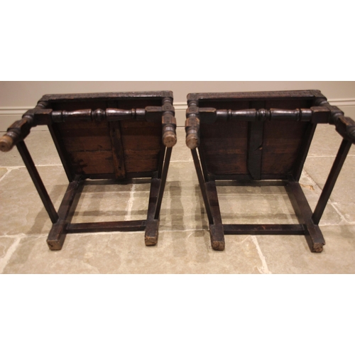 688 - A pair of carved oak hall chairs, 19th century, each with a profusely carved vasiform splat over a b... 