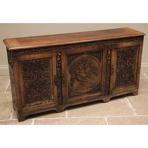 753 - A late 19th century carved oak sideboard, the central cupboard door carved in relief with the figure... 