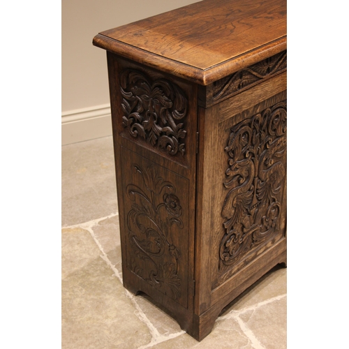 753 - A late 19th century carved oak sideboard, the central cupboard door carved in relief with the figure... 