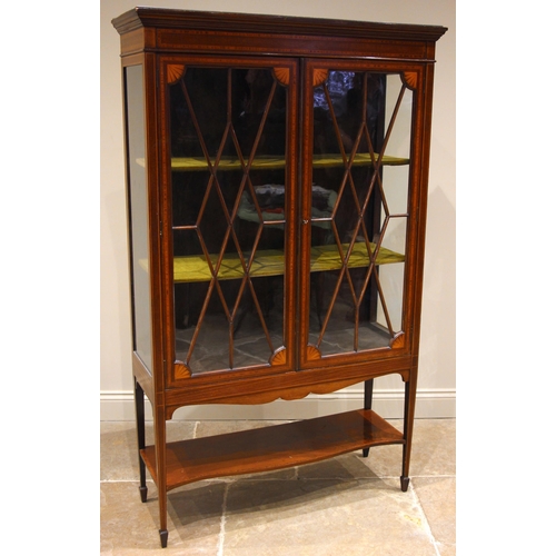 774 - An Edwardian mahogany and satinwood inlaid display cabinet, the moulded cornice over a pair of astra... 