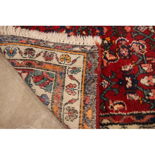 641 - A Caucasian hand knotted wool runner, the vibrant red ground with a central medallion and an all ove... 