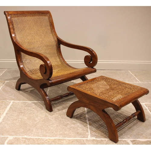 762 - A hardwood and cane work steamer type armchair and footstool, the chair of low slung form with scrol... 