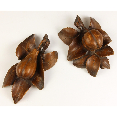 531A - A pair of Italian carved walnut hanging fruit, each carved in relief as a lobed fruit against leaves... 