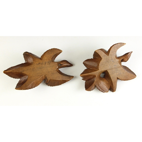 531A - A pair of Italian carved walnut hanging fruit, each carved in relief as a lobed fruit against leaves... 