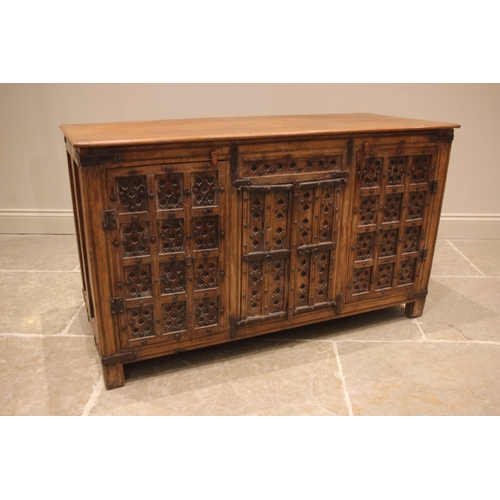 792 - An Indian hardwood sideboard, the slab top over a pair of central panelled cupboard doors, flanked b... 