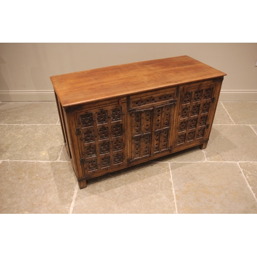 792 - An Indian hardwood sideboard, the slab top over a pair of central panelled cupboard doors, flanked b... 