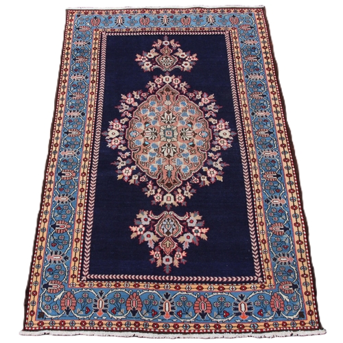 646 - A rich blue ground Persian Ardabil village rug, with a bespoke medallion design, within a sky blue b... 