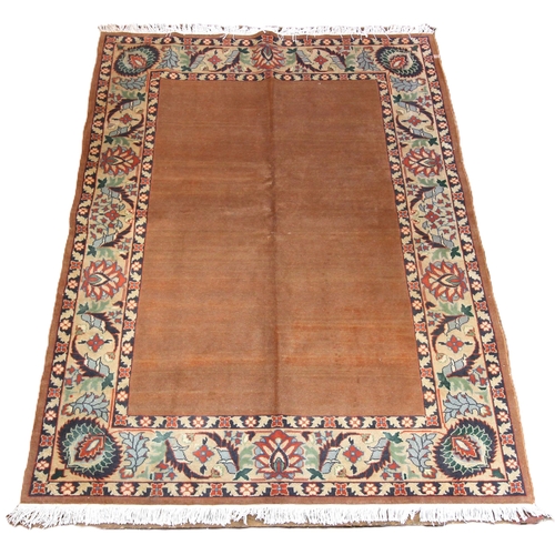 653 - A plain ground all over terracotta field Tabriz rug, with surrounding floral border, 200 x 150cm