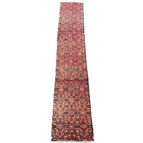 655 - A washed red ground Persian Hamadan runner, with an all over geometric design, 314 x 60cm