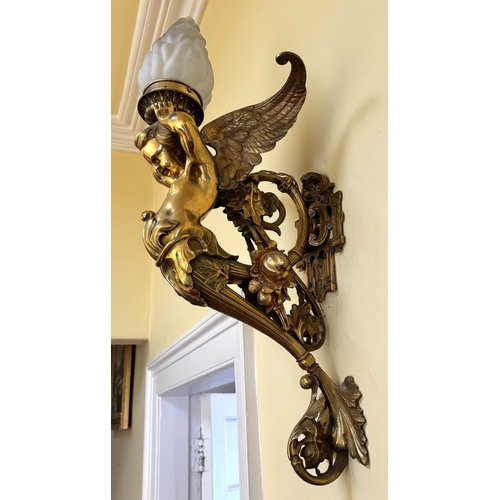 608 - A pair of French Empire style lacquered brass wall lights, each modelled as a cherub supporting a fr... 