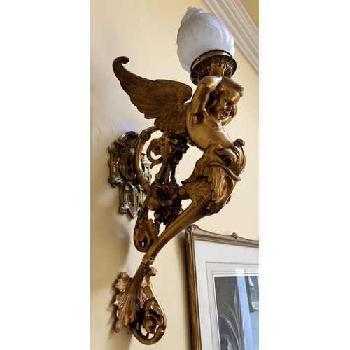 608 - A pair of French Empire style lacquered brass wall lights, each modelled as a cherub supporting a fr... 