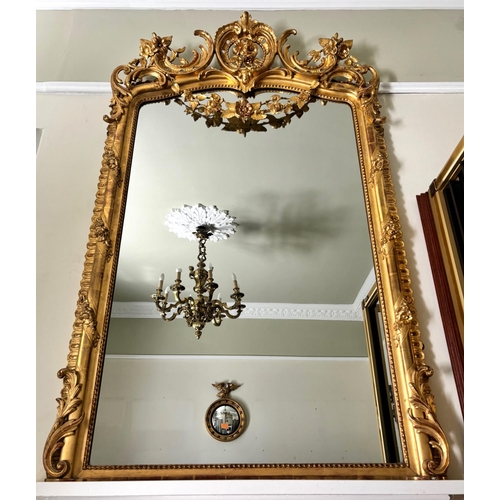 617 - A French rococo giltwood and gesso oval overmantel mirror, 19th century, the 'C' scroll and foliate ... 