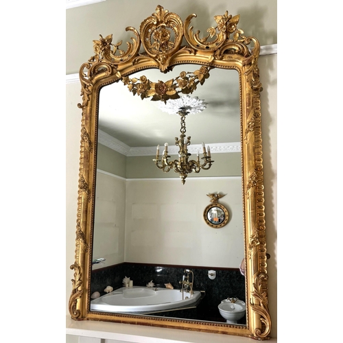 617 - A French rococo giltwood and gesso oval overmantel mirror, 19th century, the 'C' scroll and foliate ... 