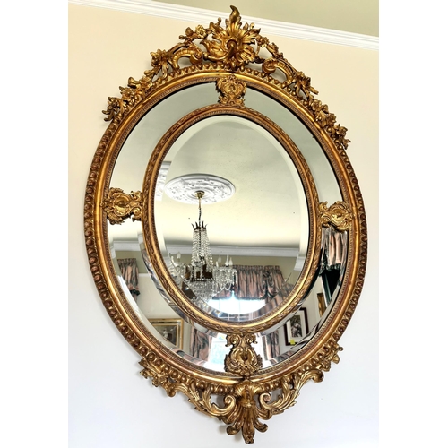 623 - A giltwood and gesso oval wall mirror, 19th century, the leaf and 'C' scroll open work crest extendi... 