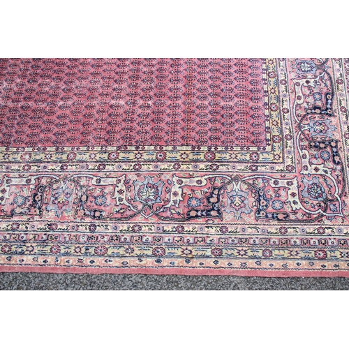 639 - A Persian pattern rug, the central pink field with an all-over gul design, enclosed by a trailing fo... 