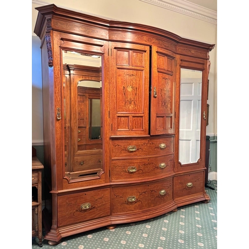 769 - An Edwardian satinwood breakfront wardrobe by Maple & Co, London, the moulded cornice over a frieze ... 