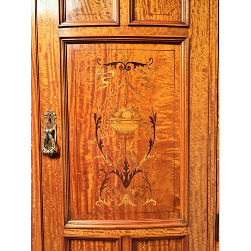 769 - An Edwardian satinwood breakfront wardrobe by Maple & Co, London, the moulded cornice over a frieze ... 