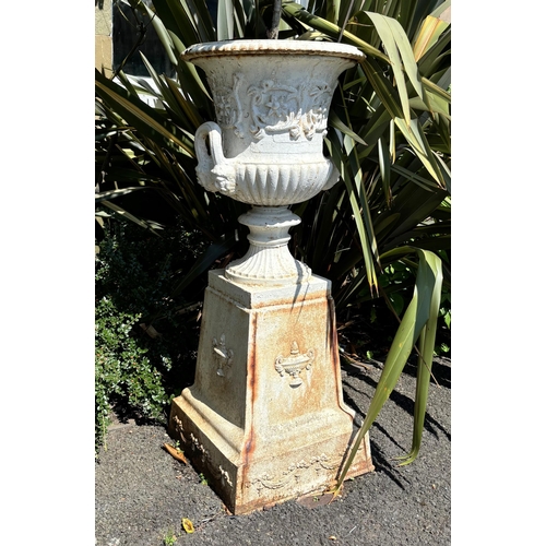 797 - A pair of cast iron white painted urns and pedestals, in the manner of Andrew Handyside, each of typ... 