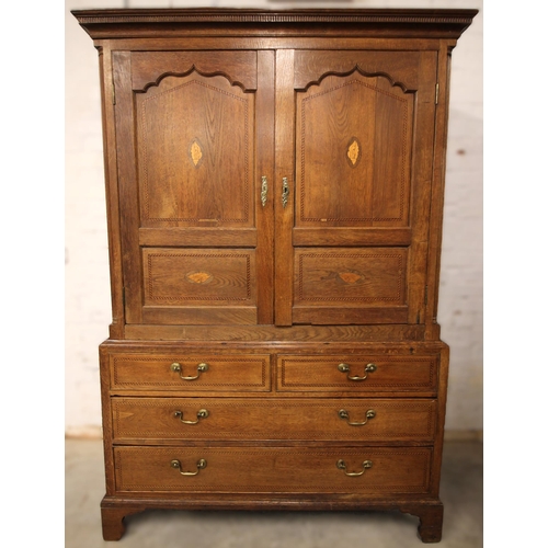 708 - A George III oak linen press, with a moulded and nulled cornice over ogee panelled doors centered wi... 