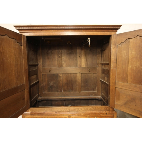 708 - A George III oak linen press, with a moulded and nulled cornice over ogee panelled doors centered wi... 