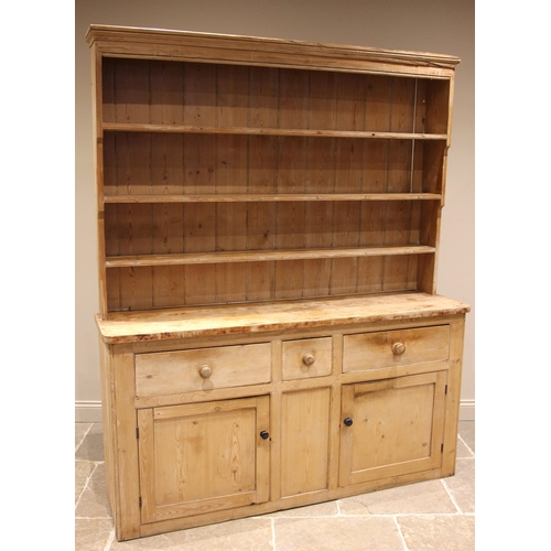 764 - A Victorian pine kitchen dresser, the enclosed plate rack with a moulded cornice over three shelves,... 