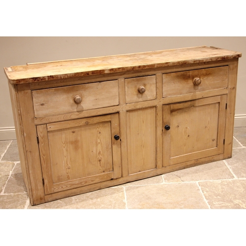 764 - A Victorian pine kitchen dresser, the enclosed plate rack with a moulded cornice over three shelves,... 