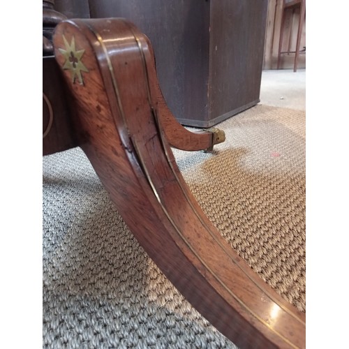 710 - A Regency rosewood and brass inlaid sofa table, in the manner of George Bullock, the drop leaf top w... 