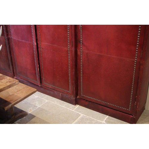 781 - An impressive and large red leather wardrobe, mid 20th century, of triple arched form, the pair of c... 