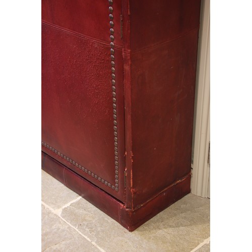 781 - An impressive and large red leather wardrobe, mid 20th century, of triple arched form, the pair of c... 