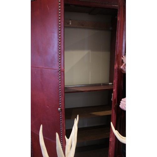 781 - An impressive and large red leather wardrobe, mid 20th century, of triple arched form, the pair of c... 