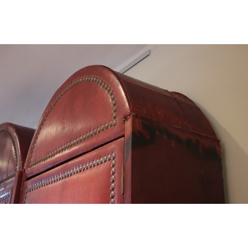 781 - An impressive and large red leather wardrobe, mid 20th century, of triple arched form, the pair of c... 