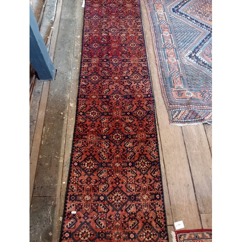 655 - A washed red ground Persian Hamadan runner, with an all over geometric design, 314 x 60cm