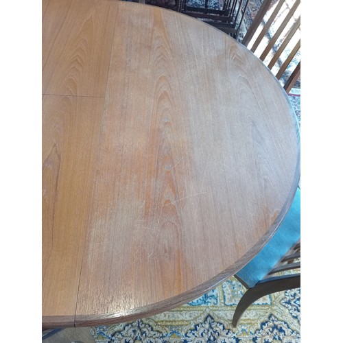 787 - A mid 20th century G Plan teak dining table with six chairs, the circular table with fold out leaf a... 