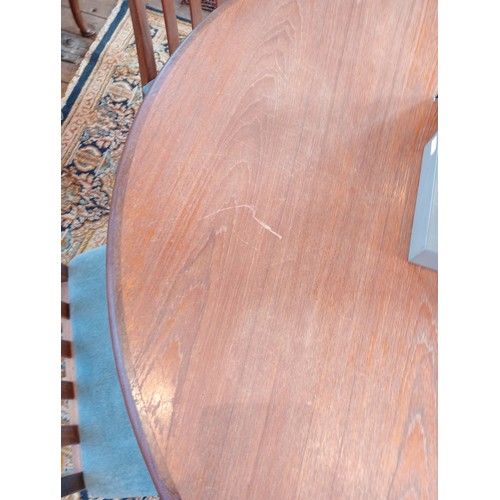 787 - A mid 20th century G Plan teak dining table with six chairs, the circular table with fold out leaf a... 