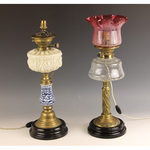 607 - A Victorian brass Hinks Duplex oil lamp, with a relief moulded milk glass reservoir upon blue and wh... 