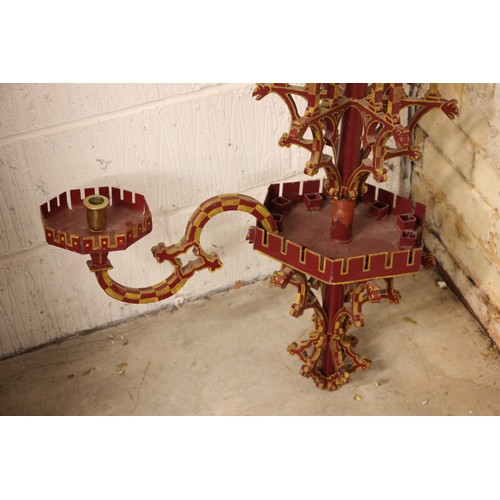 614 - A painted iron Puginesque chandelier, late 20th century, in red and yellow colourways, formed with a... 