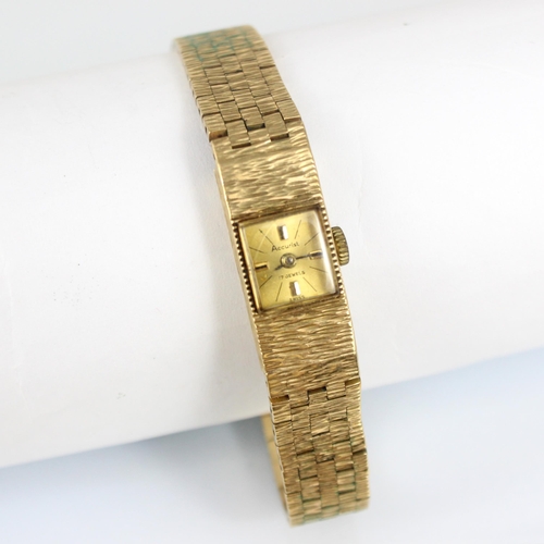 163 - A 9ct Accurist ladies wristwatch, the square coloured dial with baton markers, set to textured case ... 