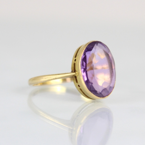 171 - An early 20th century untested amethyst ring, the oval cut amethyst within yellow metal milgrain set... 