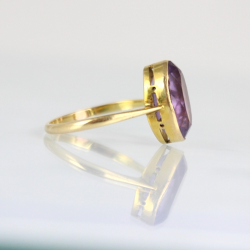 171 - An early 20th century untested amethyst ring, the oval cut amethyst within yellow metal milgrain set... 