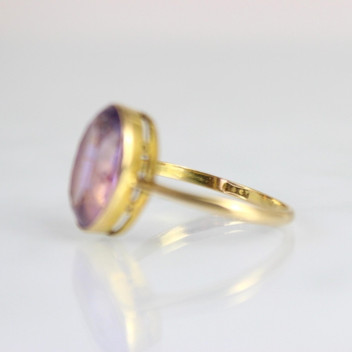 171 - An early 20th century untested amethyst ring, the oval cut amethyst within yellow metal milgrain set... 