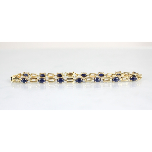 175 - A 9ct yellow gold cabochon set bracelet, the fifteen blue stone cabochons set within openwork brick ... 