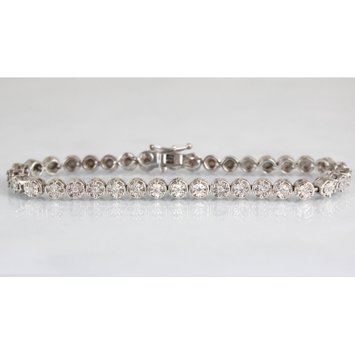 180 - A diamond line bracelet, the thirty seven round cut diamonds within white metal illusion setting edg... 