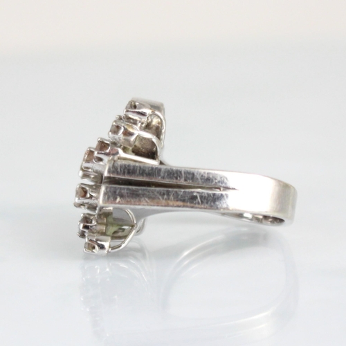 186 - An Art Deco designed diamond cocktail ring, the stylised spray of round cut diamonds with double bar... 