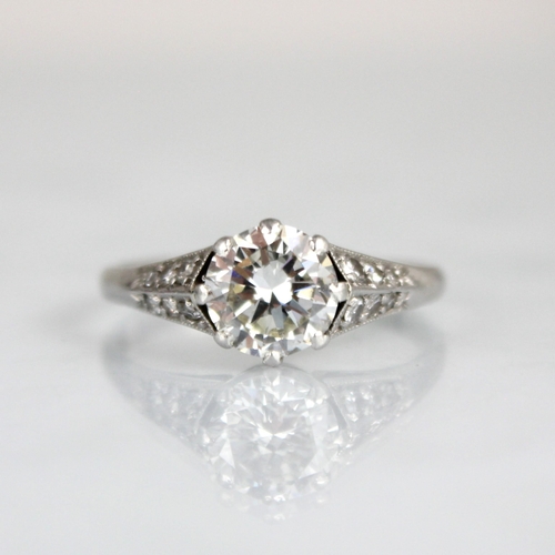 202 - An early 20th century Art Deco diamond solitaire ring, the central transitional cut diamond within w... 