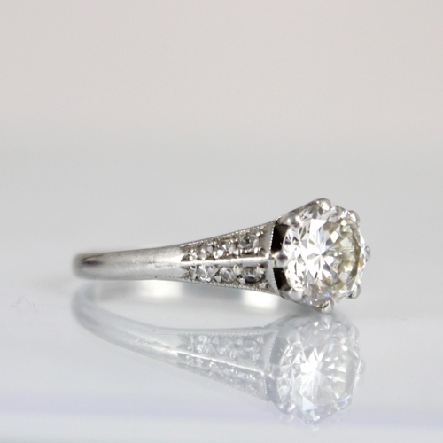 202 - An early 20th century Art Deco diamond solitaire ring, the central transitional cut diamond within w... 