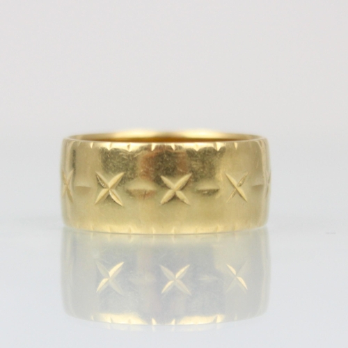 207 - An 18ct yellow gold ring, the band ring with continuous engraved decoration, stamped ‘ROP’ London 19... 