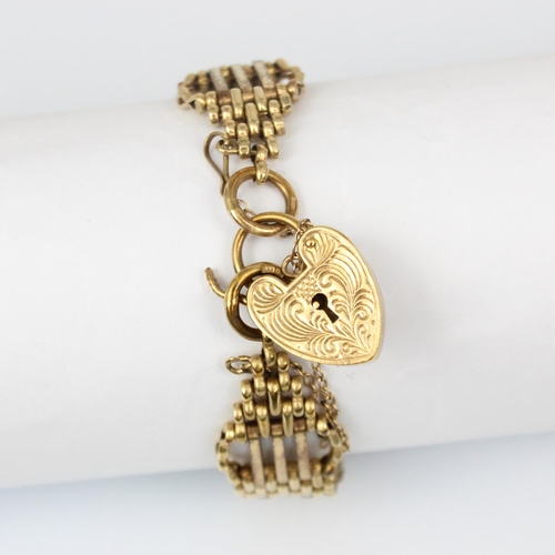 208 - A 9ct yellow gold gate link bracelet, the stylised gate link bracelet suspending a heart shaped fast... 