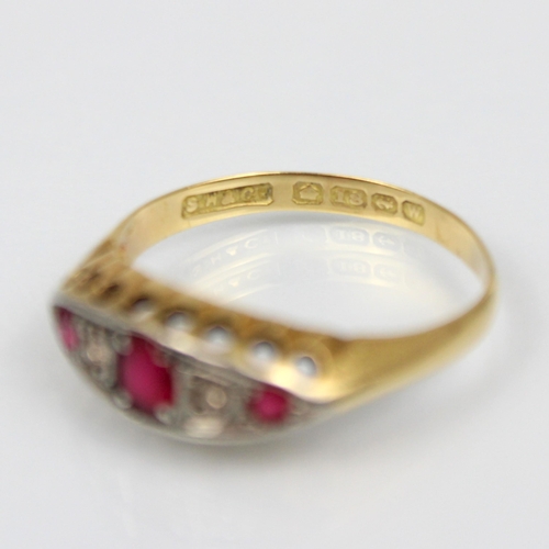 212 - An 18ct paste ring, the central red stone with white stone and further red stone set to each side, w... 