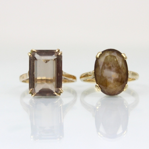 216 - A 9ct smoky quartz dress ring, the emerald cut stone within claw setting edge leading to plain polis... 